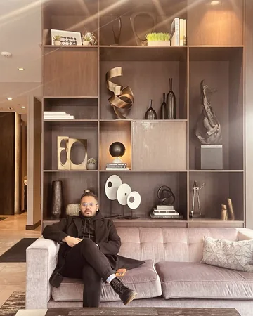 Shiv on a sofa in front of a wall of shelves